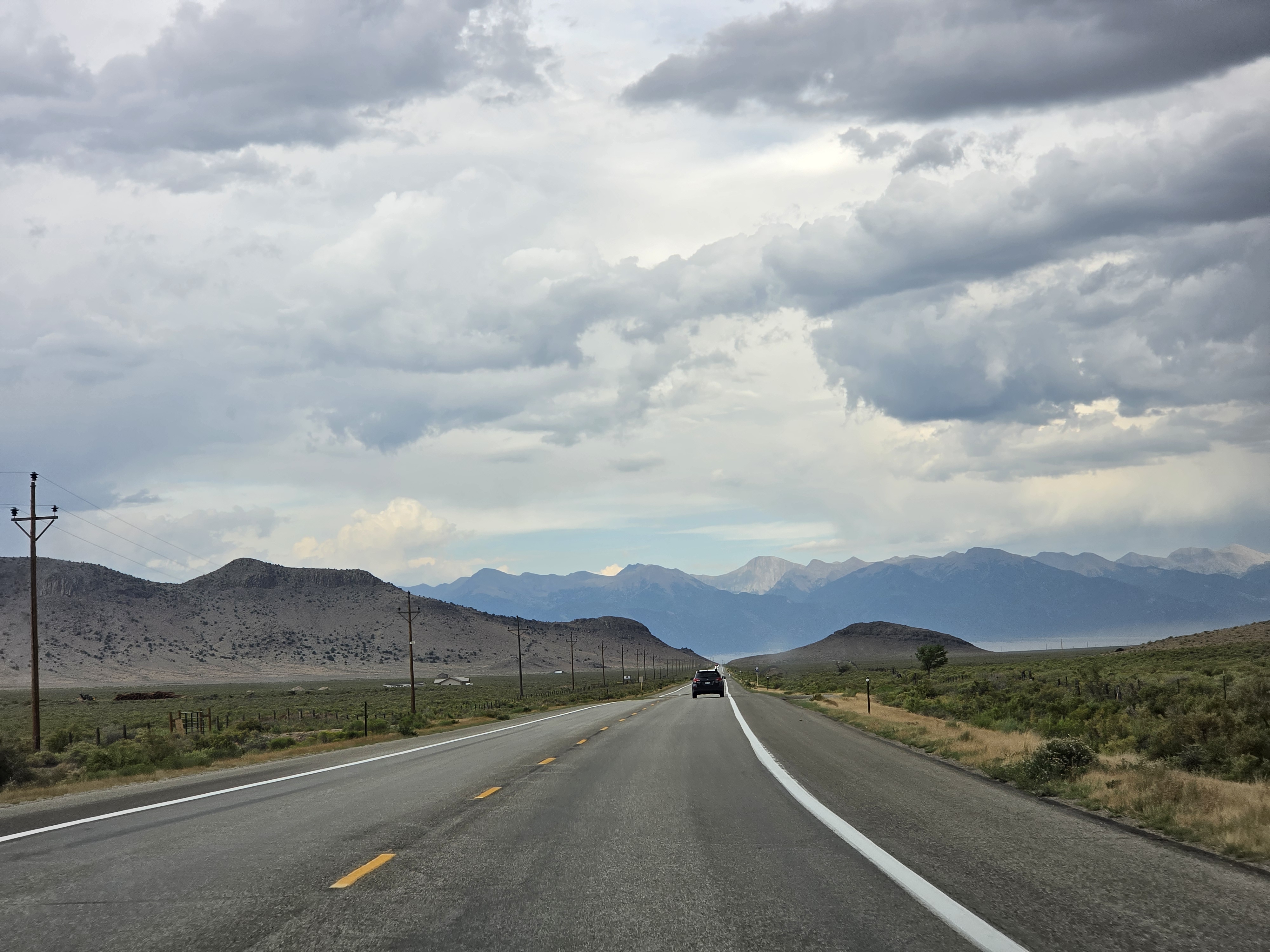 Storm clouds over the highway with the Sangre de Cristo range in the distance